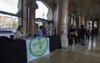 Mesa informativa AEPSAL y cola para entrar en una sala