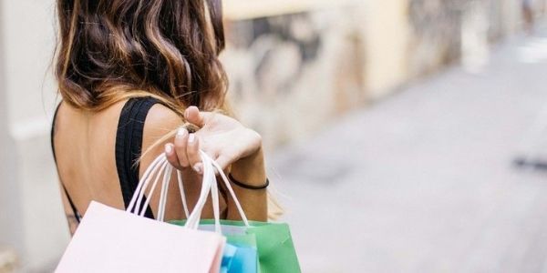 Chica cargando con bolsas de las compras realizadas