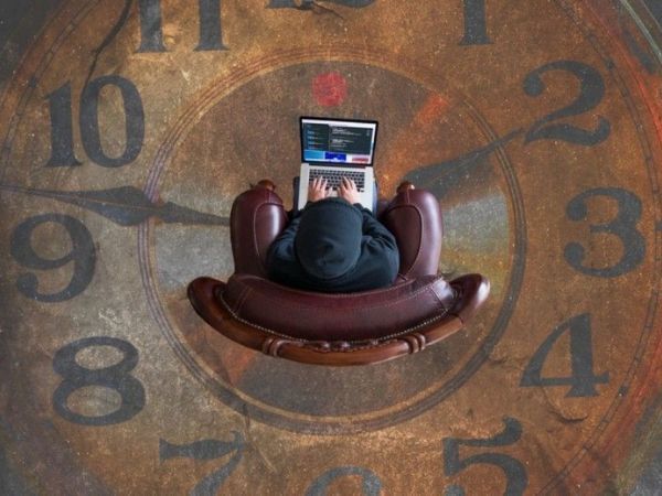Trabajador con portátil por cuenta propia encima de suelo con dibujo de reloj